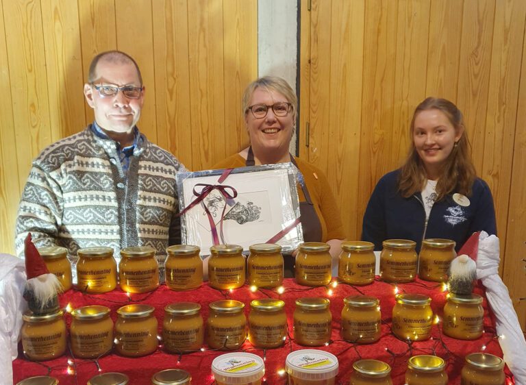 FIKK PRIS: Trine Østvand Jensen i Finnskoghonning fikk prisen for beste stand under julegata i Huset Aukrust i helga. På bildet ser vi også styreleder Leif Langodden og Nora Stormoen Jacobsen fra juryen. Foto: Huset Aukrust.